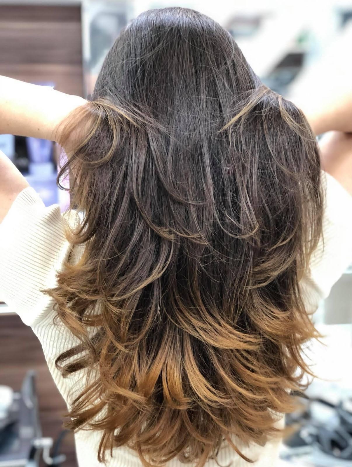 Cabelo longo em camadas com balanço natural e pontas iluminadas