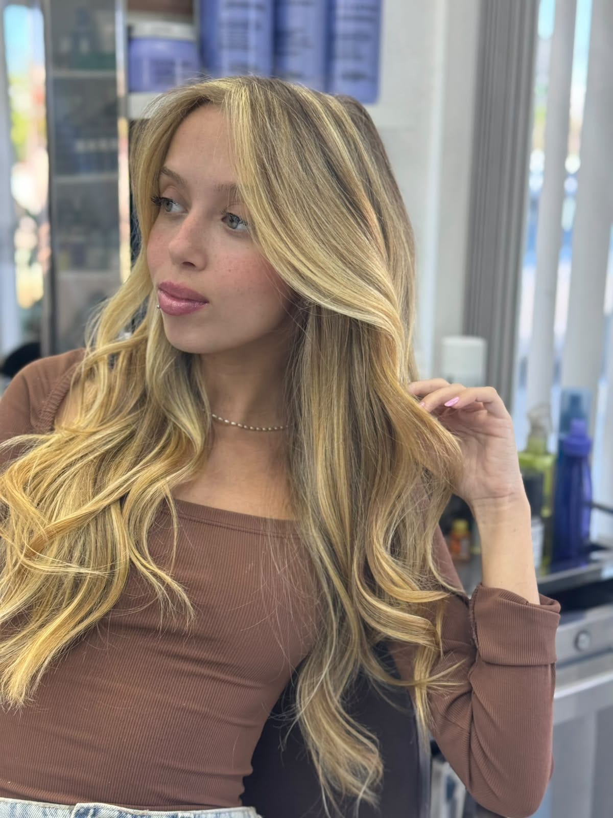 Cabelo loiro longo e ondulado com mechas luminosas